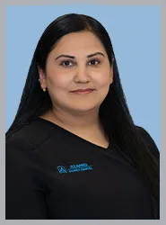 A dental professional smiling in scrubs.