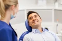A dentist and patient smiling in a dental clinic.