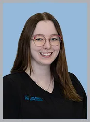 Dental professional smiling in black scrubs with logo.