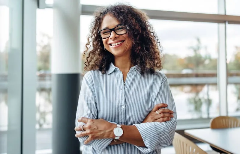 A smiling woman with curly hair indoors