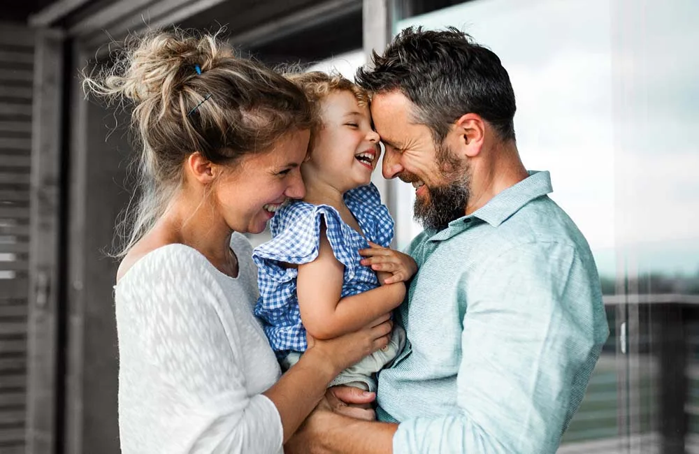 A joyful family laughing together outdoors.