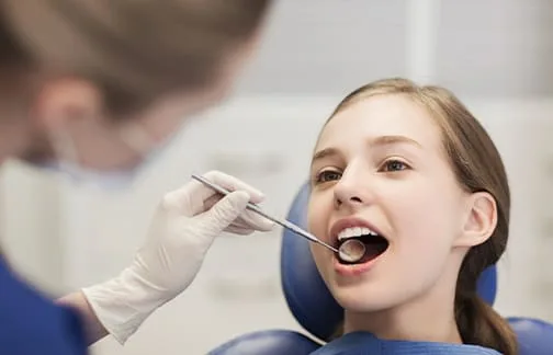 A young girl receiving a dental examination.