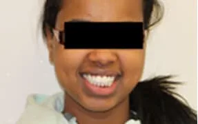 A young woman smiling with straight black hair.