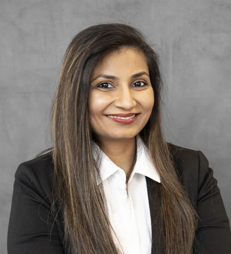 A smiling woman in a black blazer and white shirt.