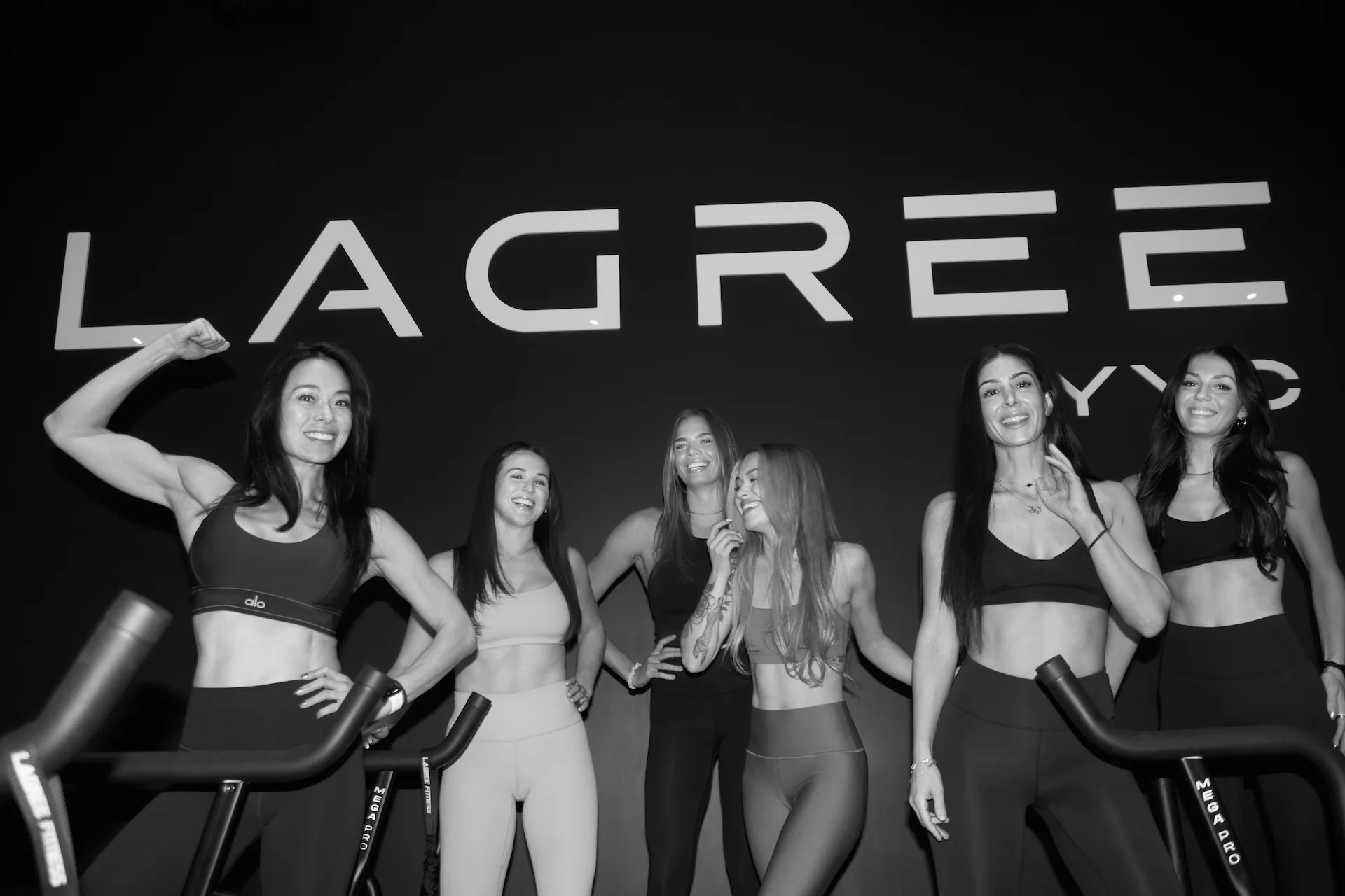 A group of women in fitness attire posing together.