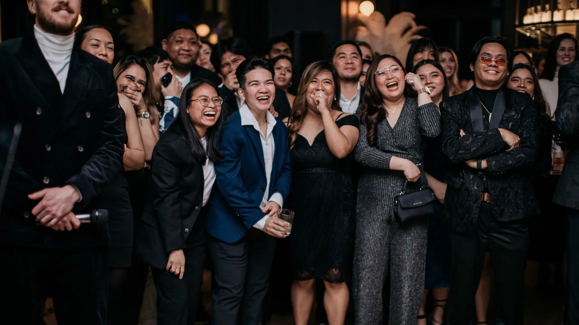 A group of people laughing at a social event.