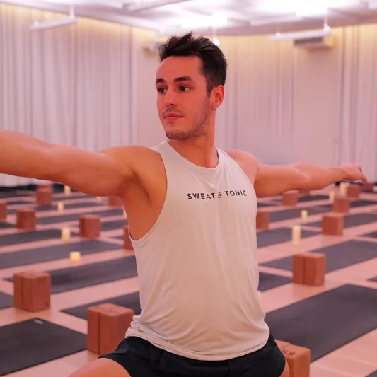 Male instructor demonstrating yoga in a studio setting.