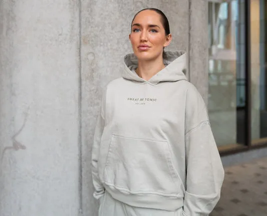 Light gray hoodie with 'Sweat and Tonic' logo.