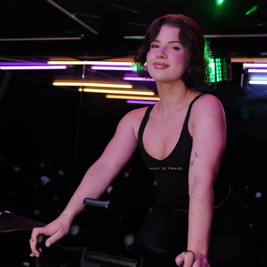 A woman on a stationary bike in a fitness studio.
