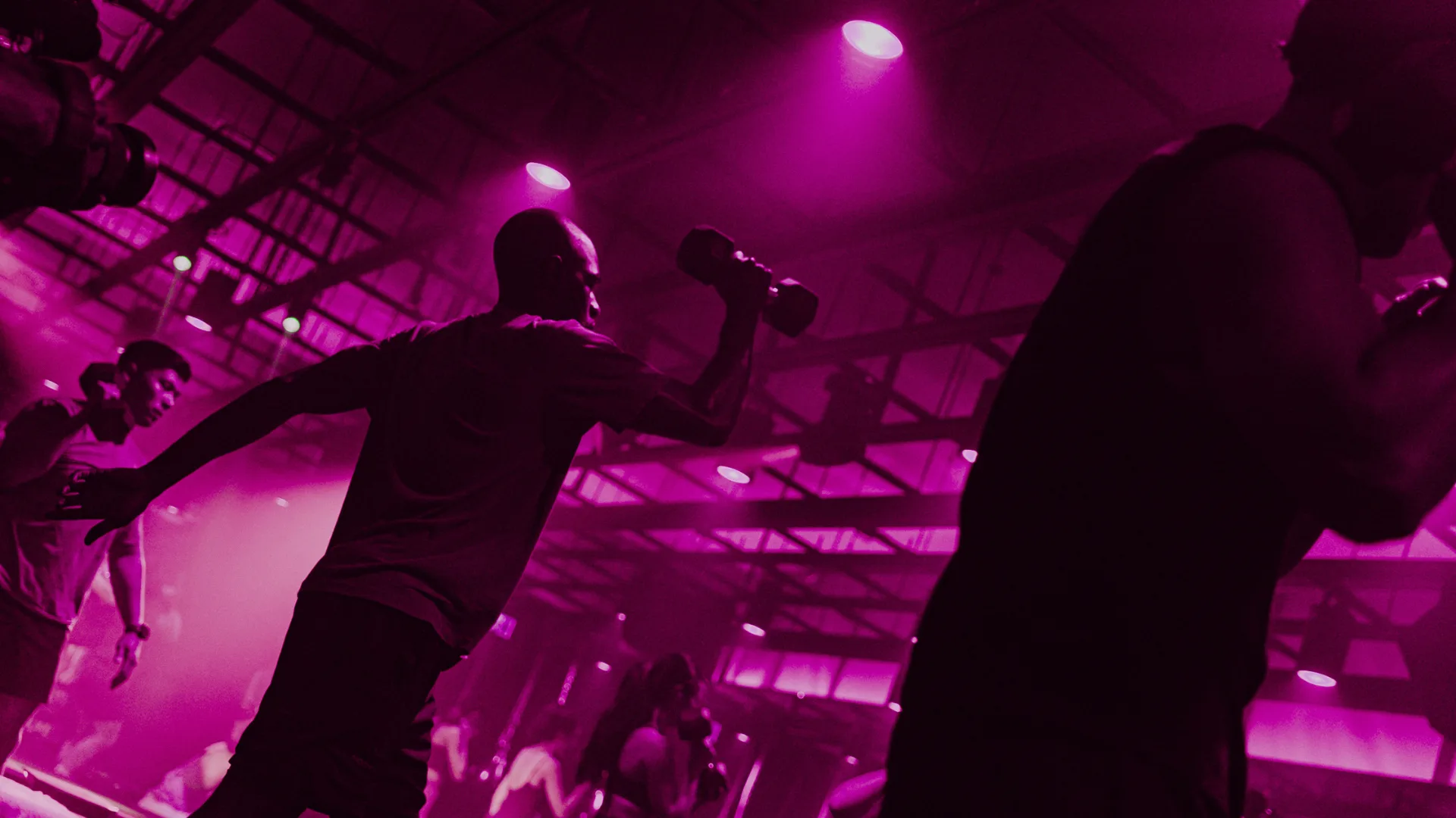 Participants in a boxing HIIT class with purple lighting.