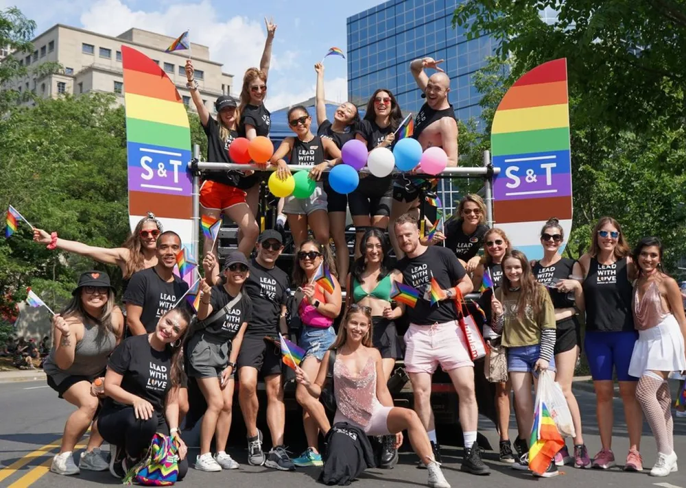Group of people celebrating at a pride parade with a float.