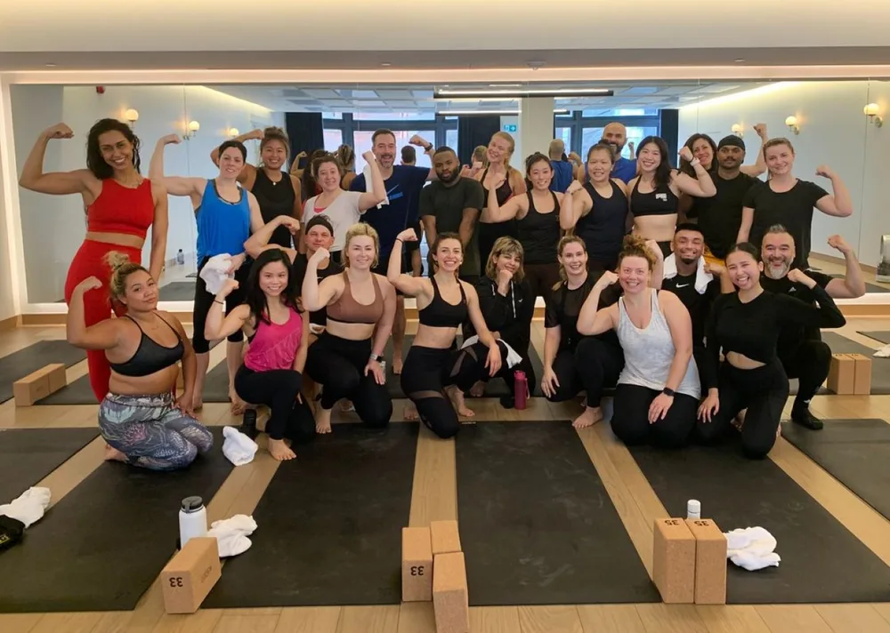Group of fitness enthusiasts posing in a studio