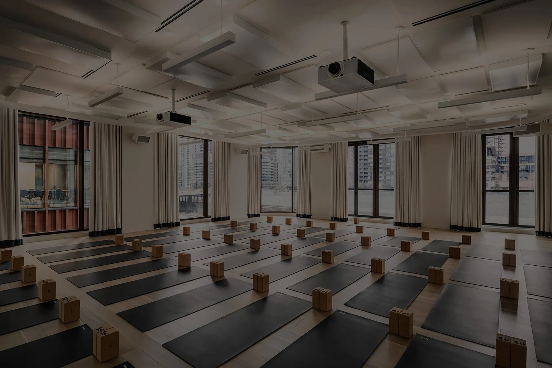 Spacious yoga studio with black mats and wooden blocks.