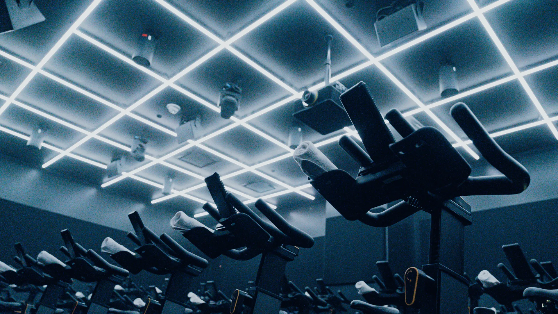 An indoor cycling studio with illuminated ceiling lights.