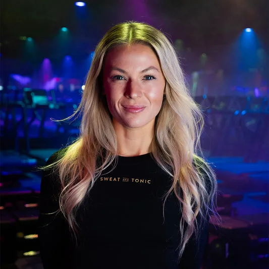 A fitness instructor smiling in a studio setting.
