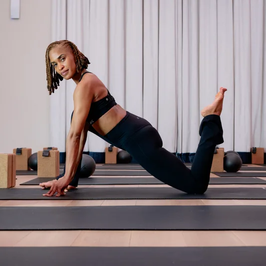 A woman doing yoga in a fitness studio.