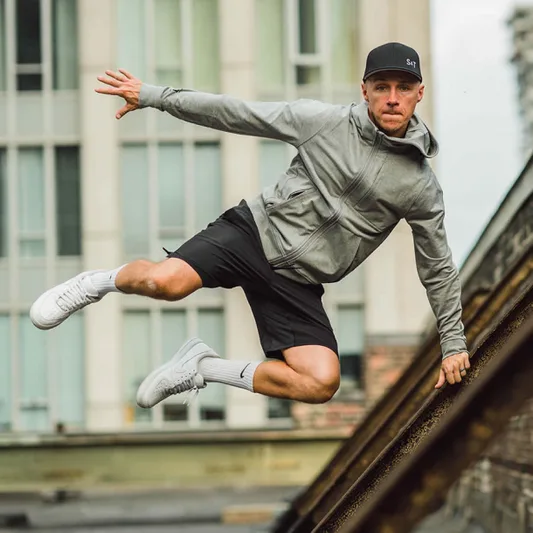 A man performing an action pose on a rooftop.