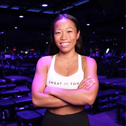 A fitness instructor smiling in a workout studio.