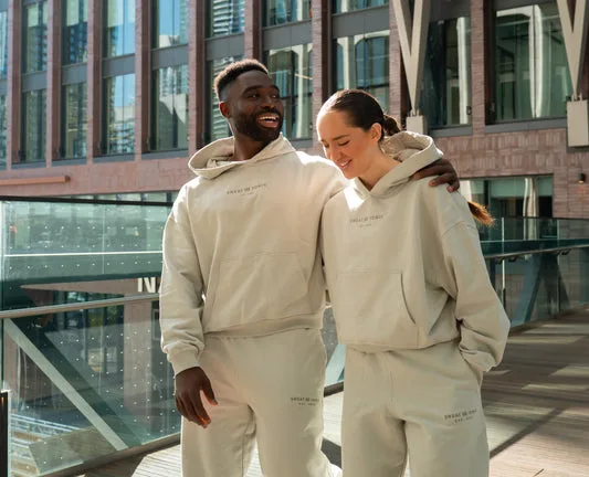 Two people in matching gray outfits on a balcony.
