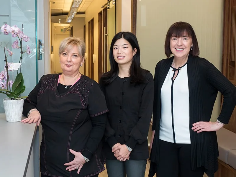 Three dental professionals in a modern dental office.