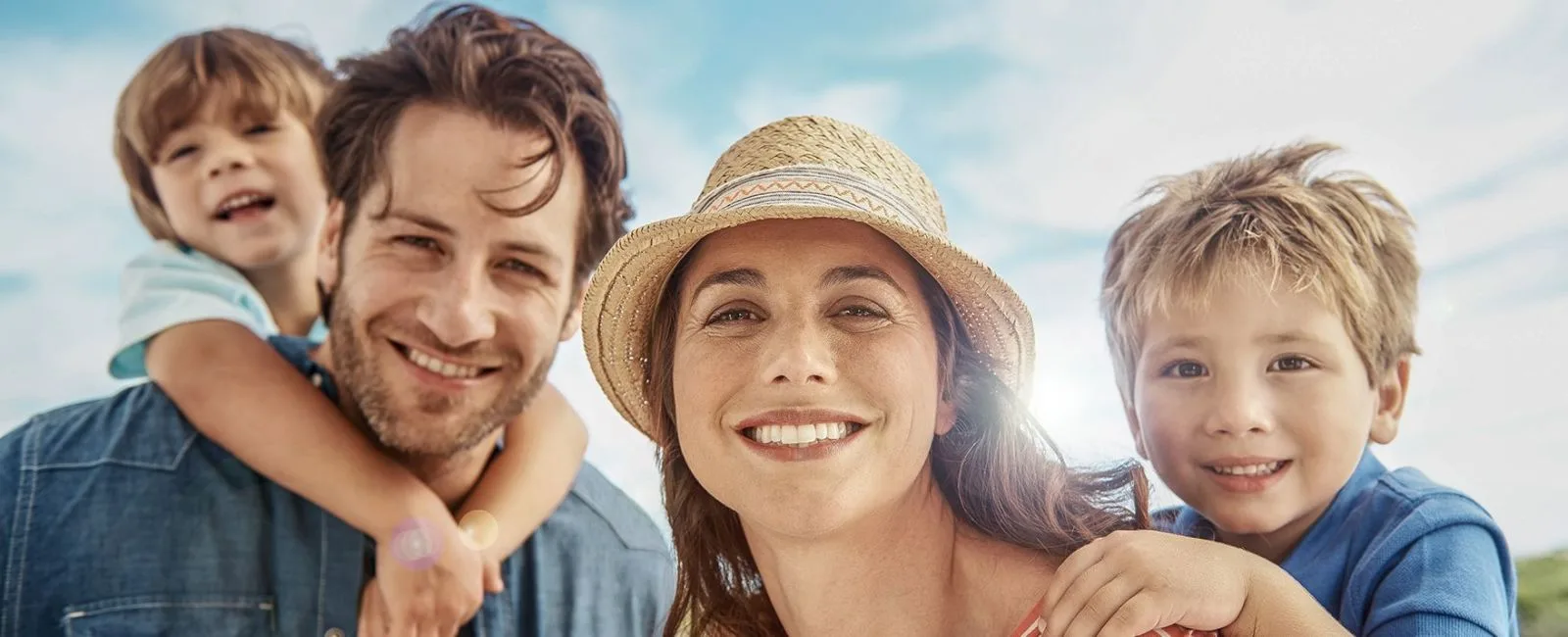 A smiling family enjoying a sunny day outdoors.