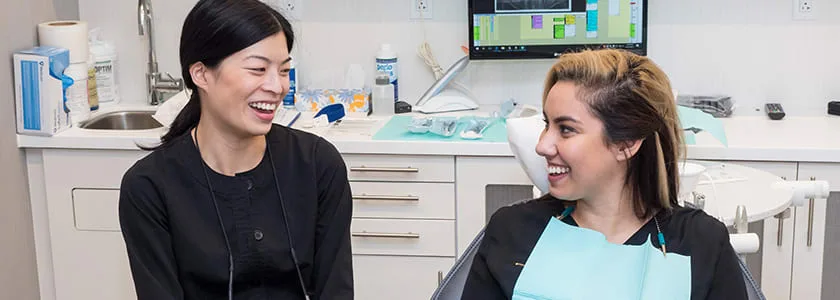 Two smiling dental professionals in a modern office.
