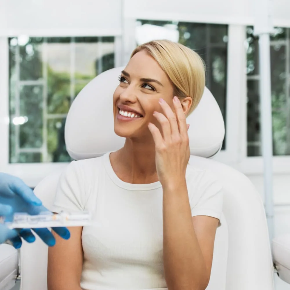 A woman smiling in a dental chair during a procedure.