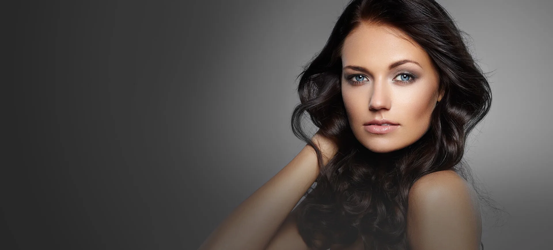 A woman with long dark hair and blue eyes.