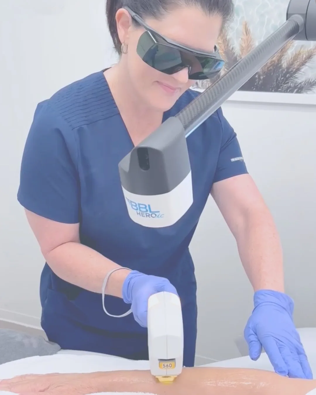 Technician administering a laser treatment in a clinic.