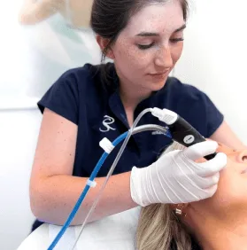 A technician performing a facial treatment on a client.