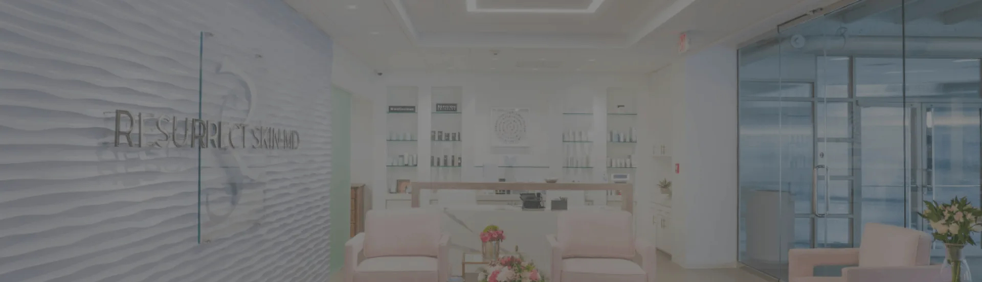 Interior of a modern aesthetic clinic with pink chairs.